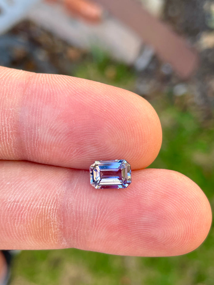 High-Resolution Image of a Precision Emerald Cut Tanzanite Gemstone in Teal Blue and Purple Colors, Weighing 1.70 Carats, with Dimensions 8.49 x 5.85 x 3.98 mm, Originating from Merelani Hills, Arusha Region, Tanzania - No Treatment