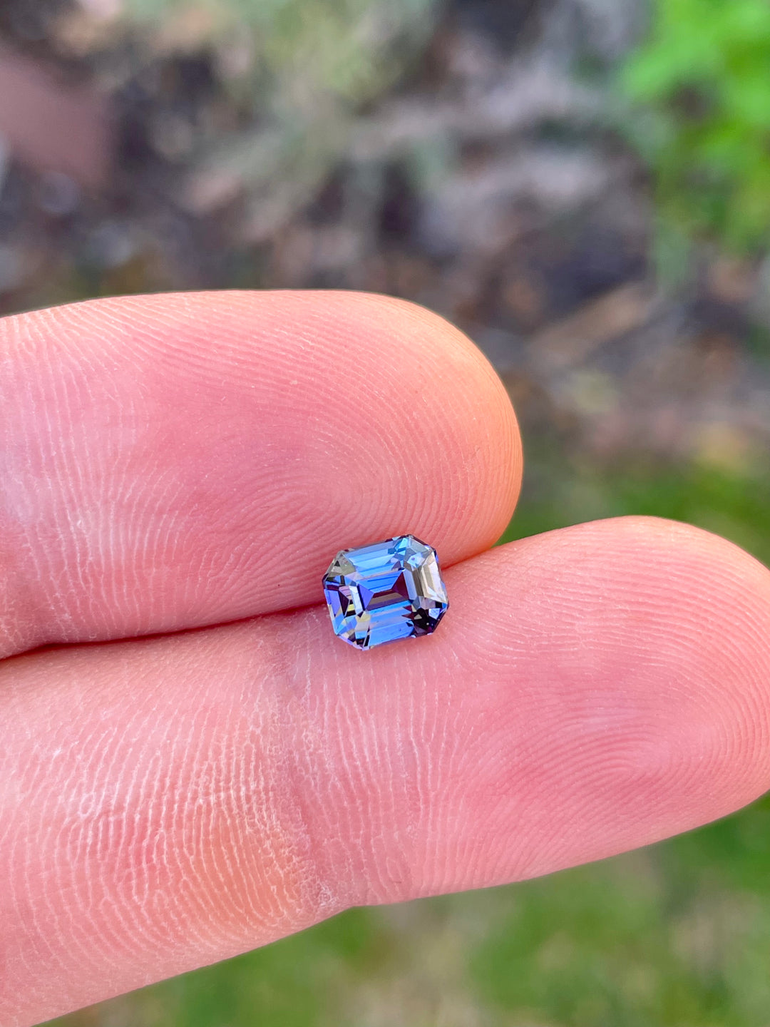 High-Resolution Image of a Custom Modified Emerald Cut Tanzanite Gemstone in Teal, Blue, Green, and Purple Colors, Weighing 1.32 Carats, with Dimensions 6.49 x 5.58 x 4.60 mm, Originating from Merelani Hills, Arusha Region, Tanzania - No Treatment