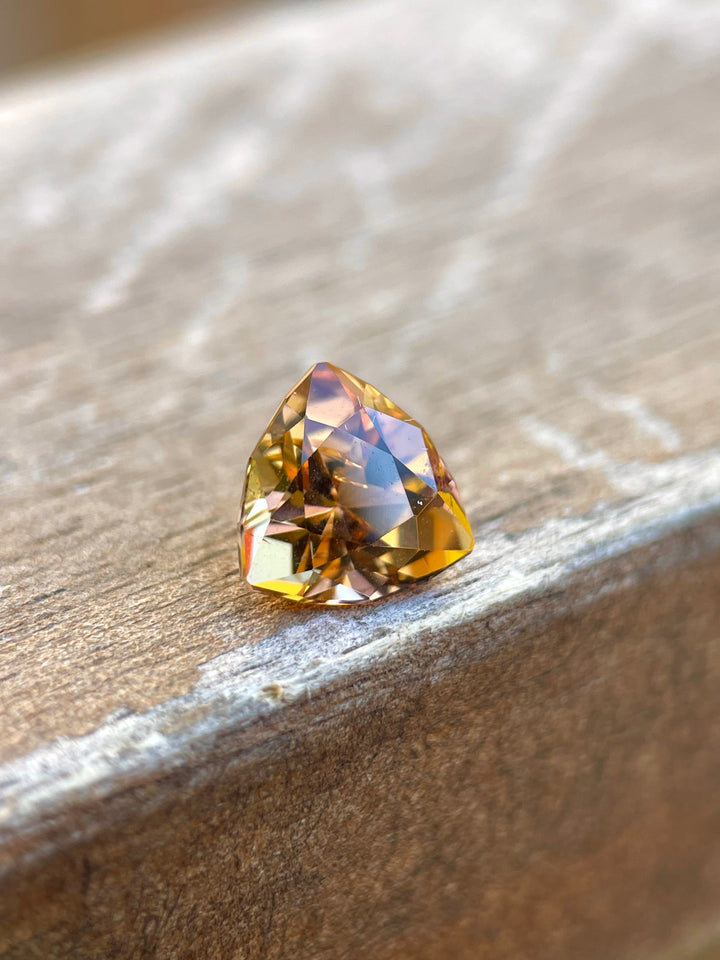 Image of a Custom Trilliant Cut Tanzanite Gemstone in Vivid Peach Orange Color, Weighing 2.01 Carats, with Dimensions 8.06 x 8.14 x 5.32 mm, Originating from Merelani Hills, Arusha Region, Tanzania - No Treatment