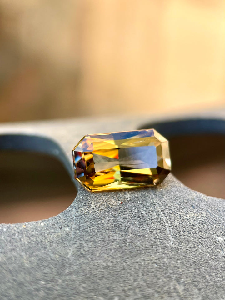 Custom Elongated Radiant Cut Tanzanite Gemstone in Greenish Golden, Peach, and Yellow Colors, Weighing 2.30 Carats, with Dimensions 10.59 x 6.05 x 4.43 mm, Originating from Merelani Hills, Arusha Region, Tanzania - No Treatment