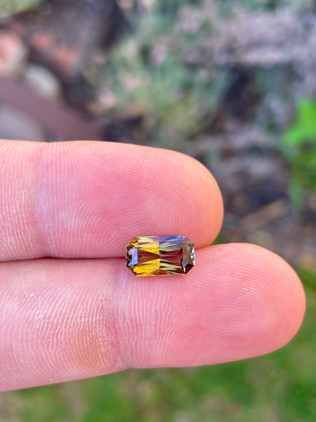 Detailed Image of a Custom Elongated Radiant Cut Tanzanite Gemstone in Greenish Golden, Peach, and Yellow Colors, Weighing 2.30 Carats, with Dimensions 10.59 x 6.05 x 4.43 mm, from Merelani Hills, Arusha Region, Tanzania - No Treatment