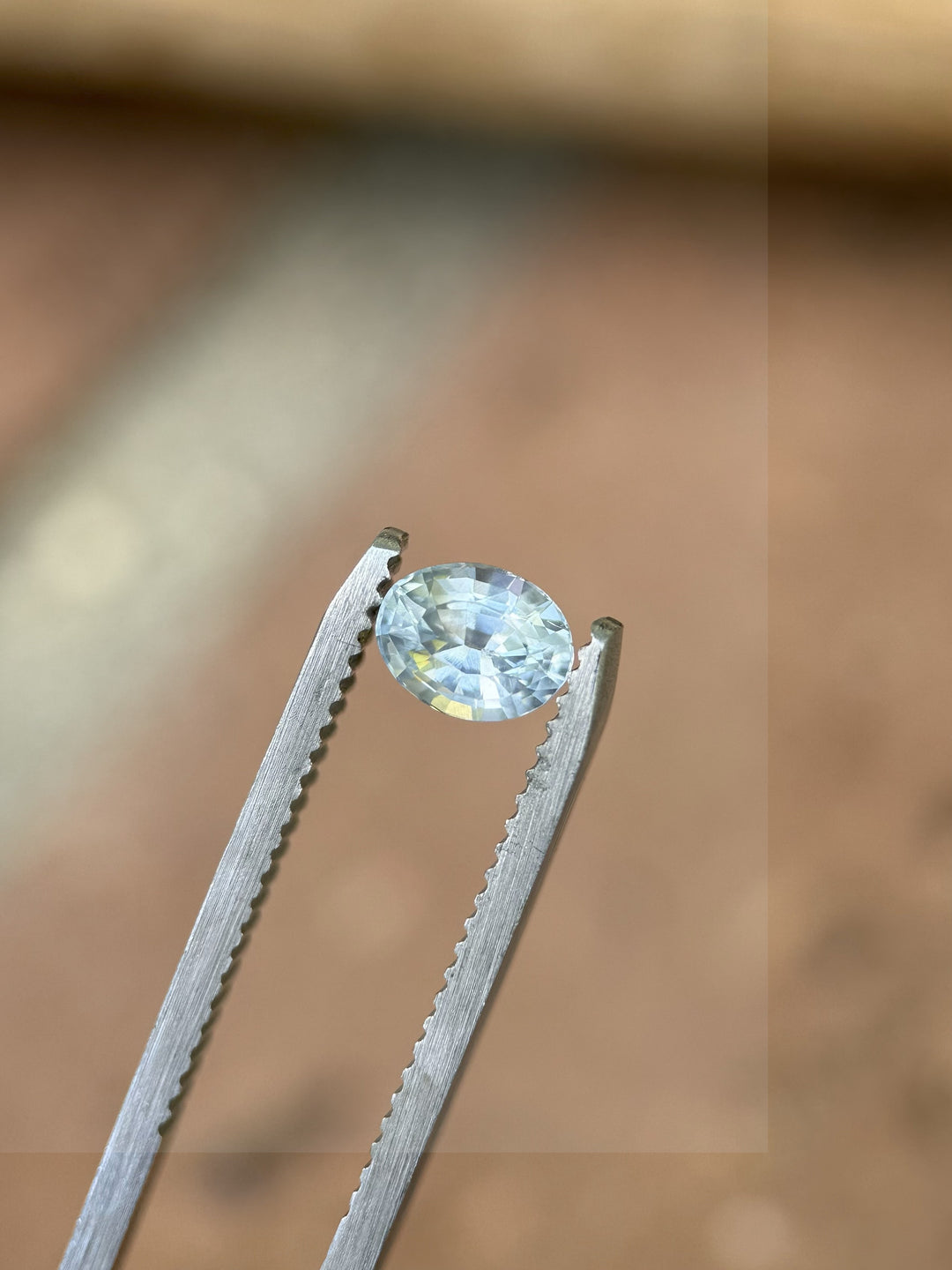 Montana origin sapphire in oval mix cut placed on rustic surface showing natural brilliance