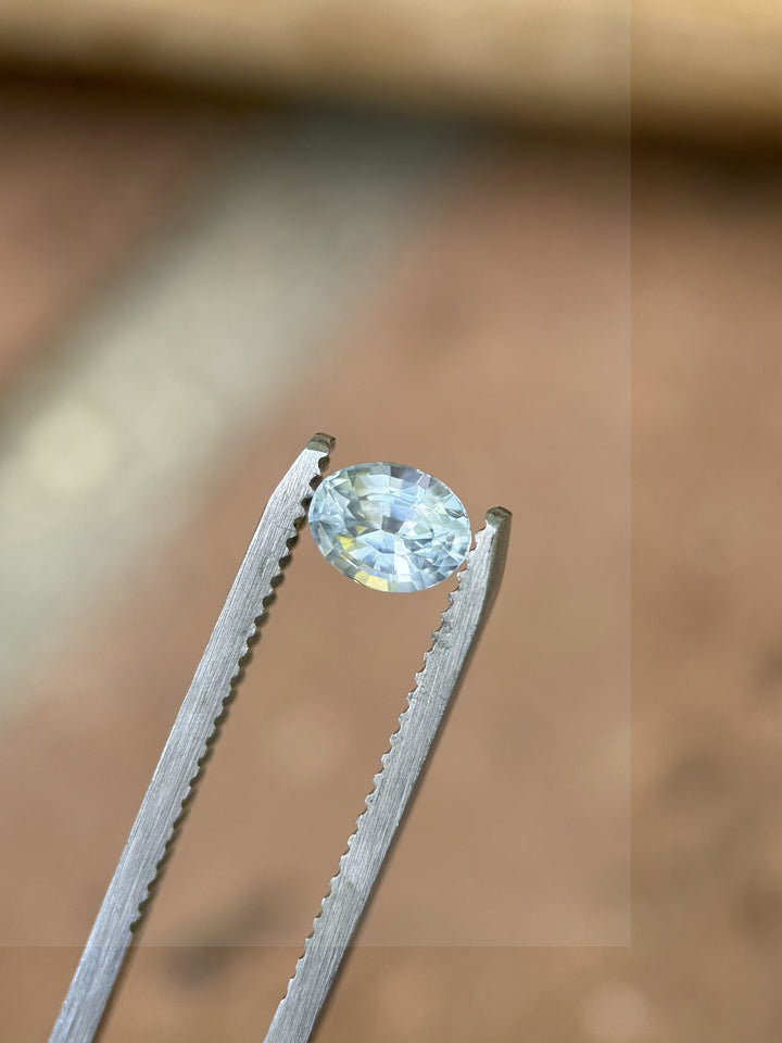 Montana origin sapphire in oval mix cut placed on rustic surface showing natural brilliance