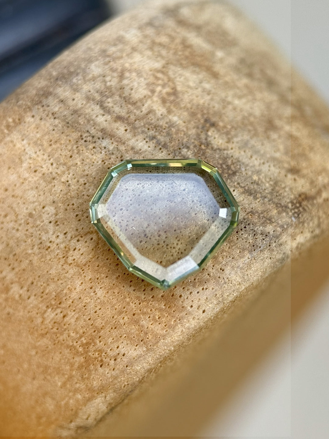 Top view of a 2.58ct sapphire from Montana with bluish seafoam green color, cut in a custom shield portrait style