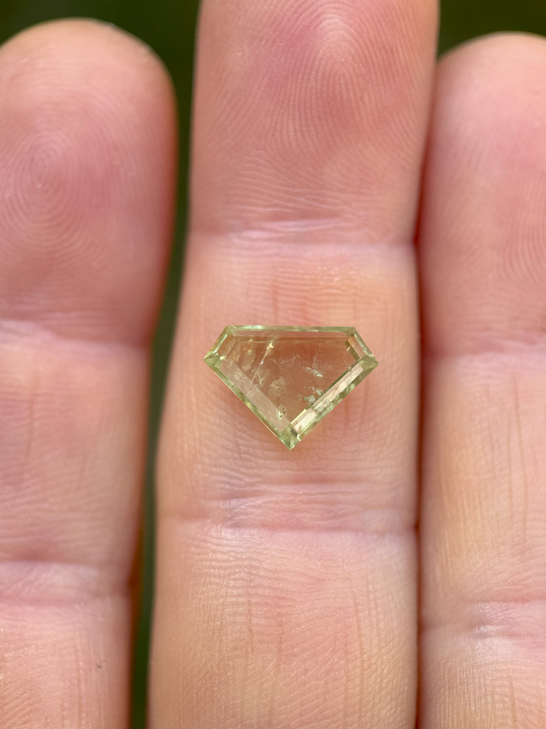 Heated 3.03ct green sapphire from Montana, photographed to highlight shield portrait faceting and color zoning.