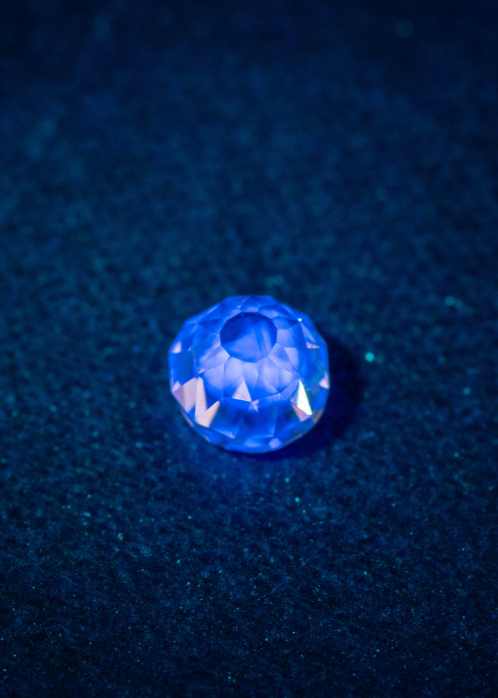 0.70-carat fancy light brown rosy champagne diamond showing very strong blue fluorescence under UV light, photographed to highlight the Mughal cut facets and natural color. VVS1 clarity diamond from South Africa displayed glowing bright blue due to fluorescence.