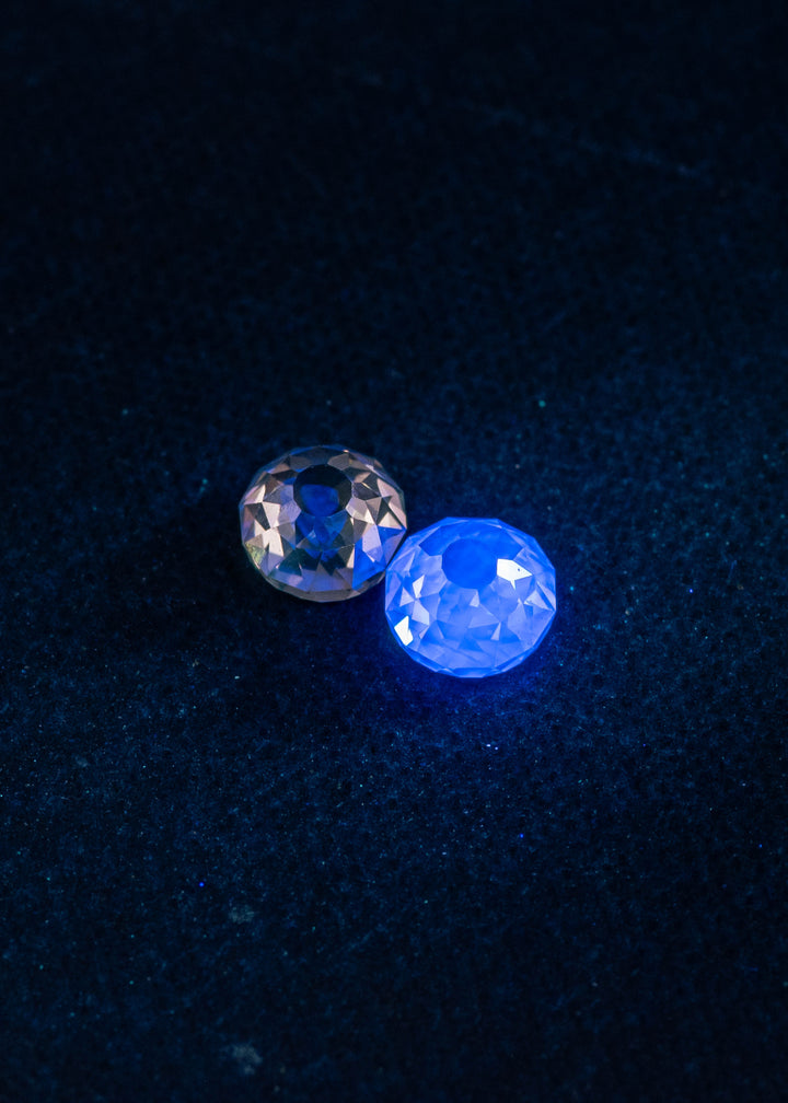 Matched Mughal cut diamonds totaling 1.11CT glowing with medium blue and yellow fluorescence under UV light, highlighting the Fancy Light Brown C3 color and antique faceting.