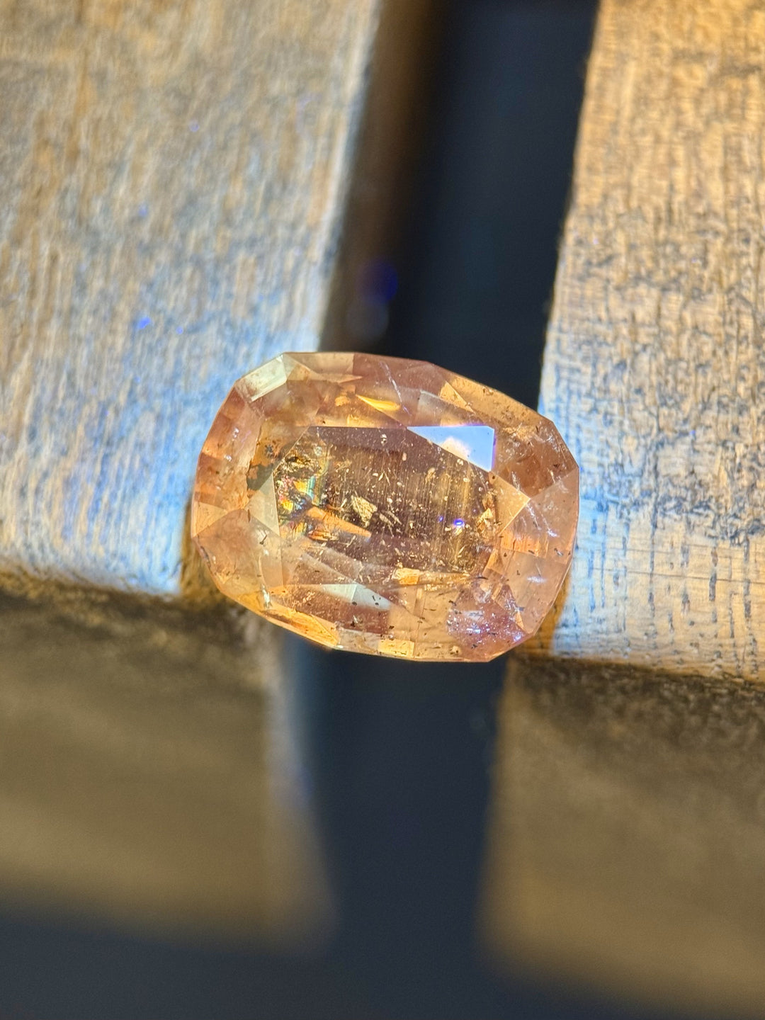 Natural sapphire from Tanzania in a mixed antique cushion cut, 4.02 carats, shown under daylight with earthy hues and unique internal patterns.