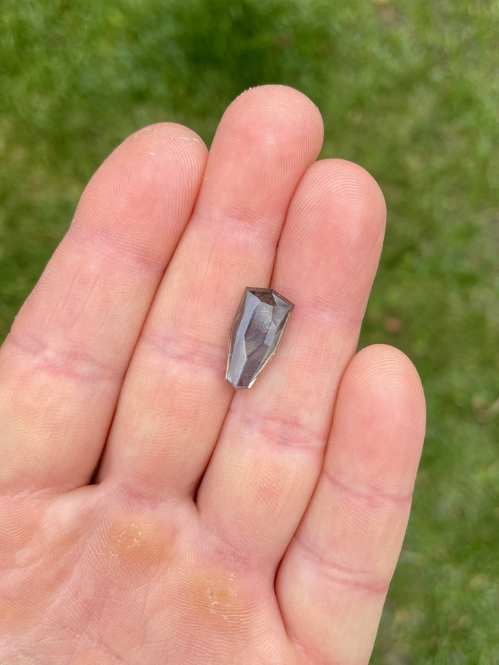 Detailed view of custom-cut sapphire displaying color shift and intricate faceting, Umba River source.