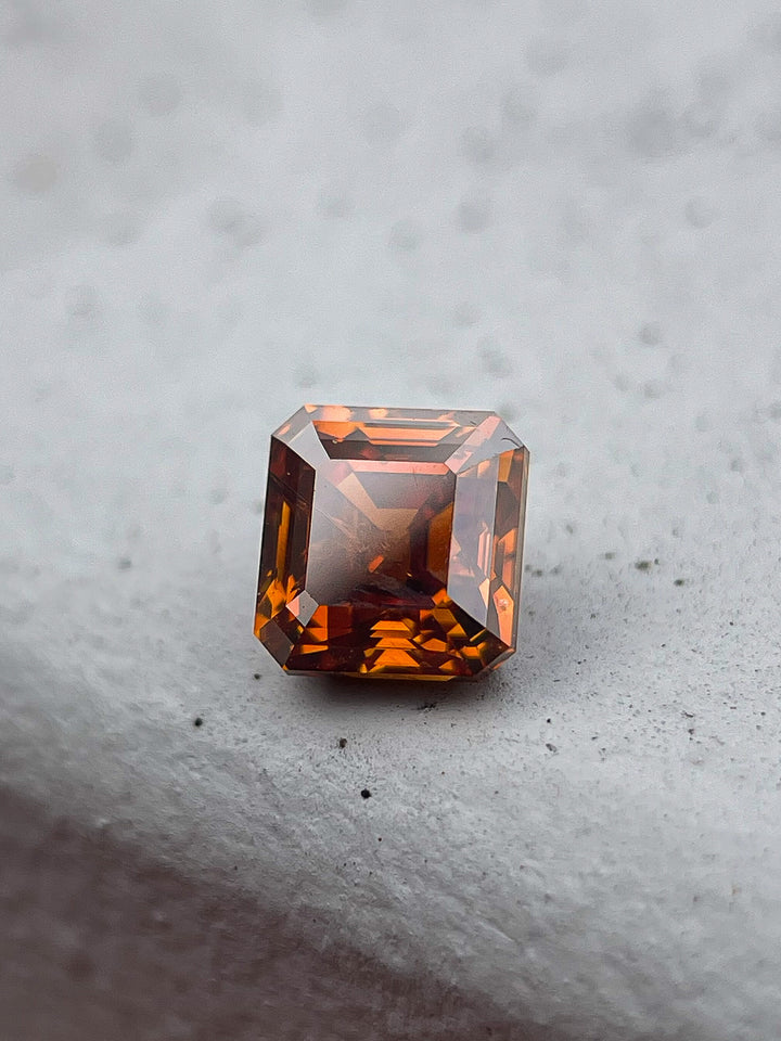 tunning 1.01-carat natural cognac red diamond in an octagonal step cut, sourced from South Africa. This untreated gemstone showcases deep red and amber hues with exceptional brilliance.