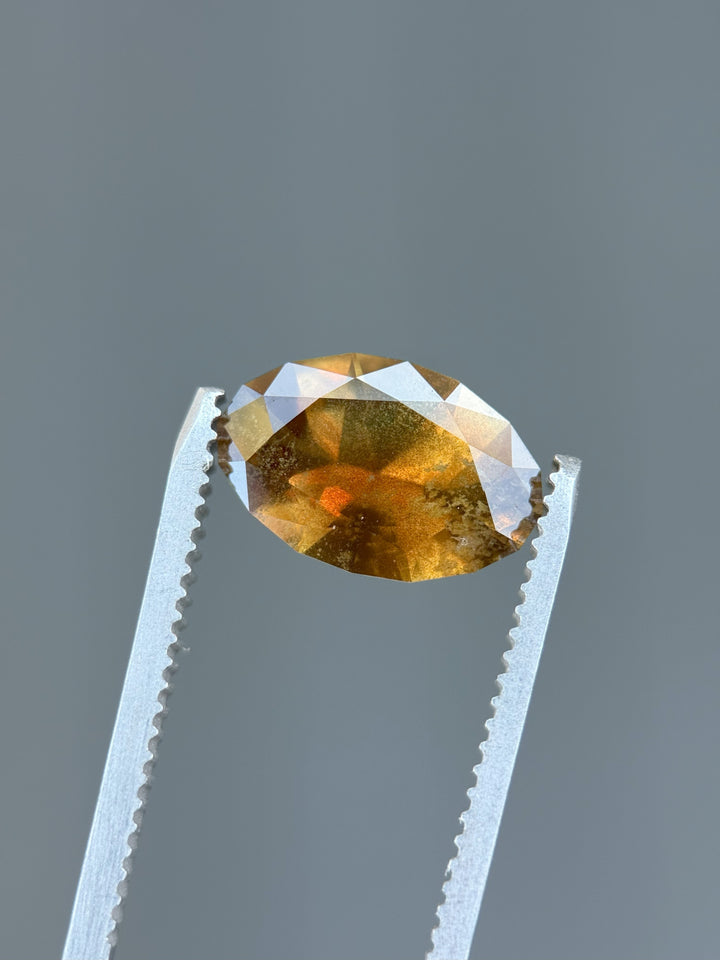 Macro of untreated 3.45 carat sapphire in elongated oval cut, highlighting vibrant golden and green color shift