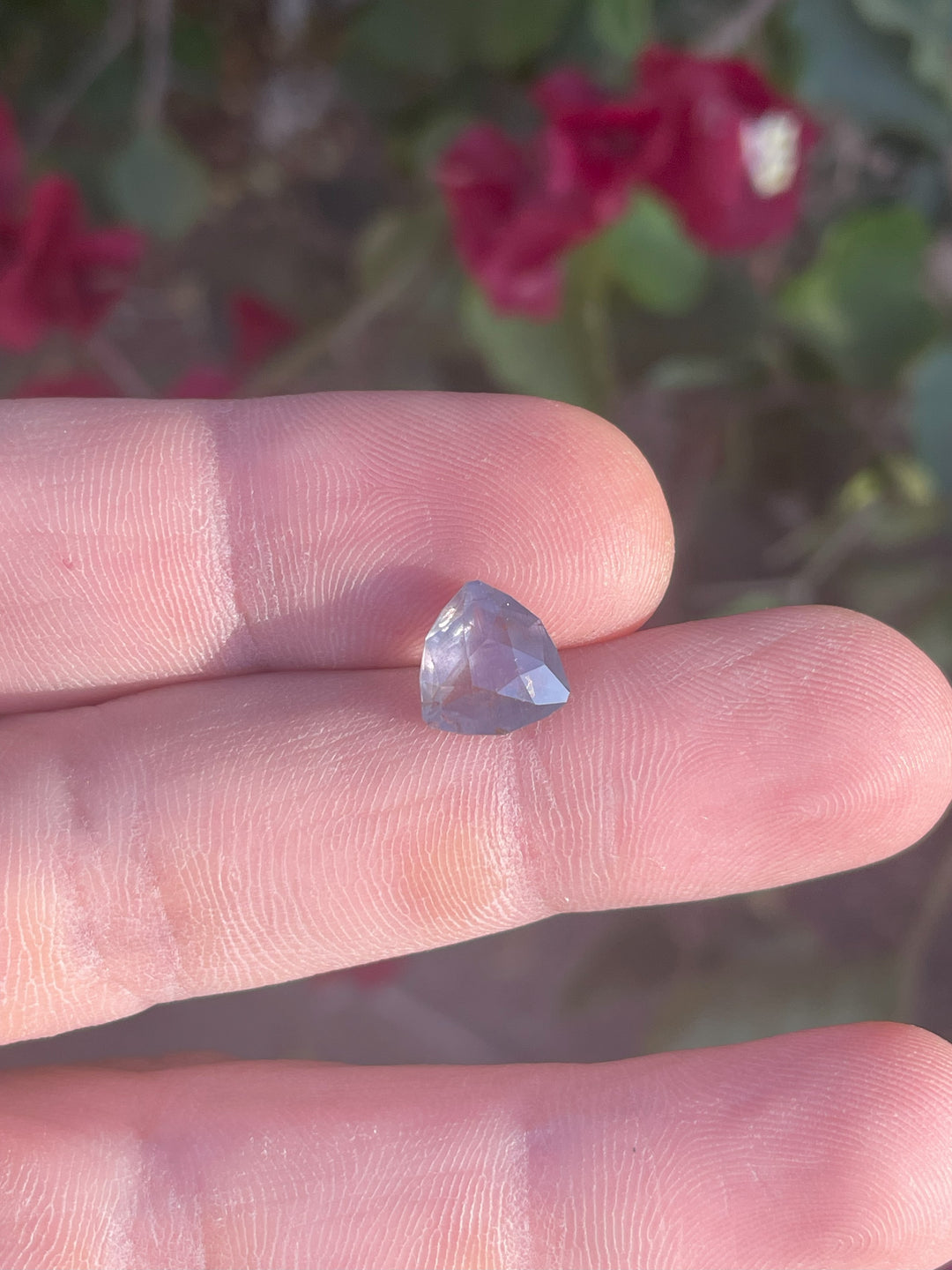 A 4.19-carat sapphire in a custom geometric trillion cut. The gemstone displays captivating gray, teal, and yellow tones with a remarkable color-changing quality. Untreated and ethically sourced from Tanzania.