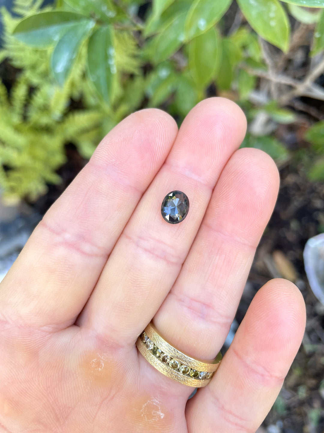 A 1.72-carat oval-shaped sapphire with a mix cut, showcasing a blend of green, blue, and teal hues. The gemstone is untreated and sourced ethically from Madagascar.