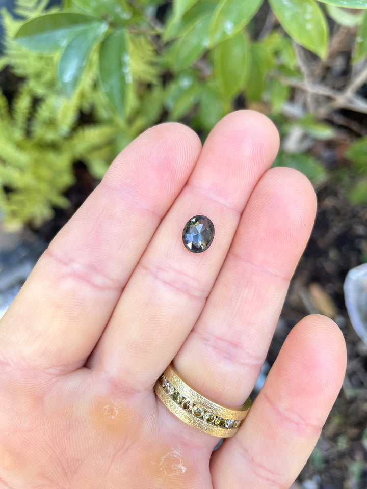 A 1.72-carat oval-shaped sapphire with a mix cut, showcasing a blend of green, blue, and teal hues. The gemstone is untreated and sourced ethically from Madagascar.