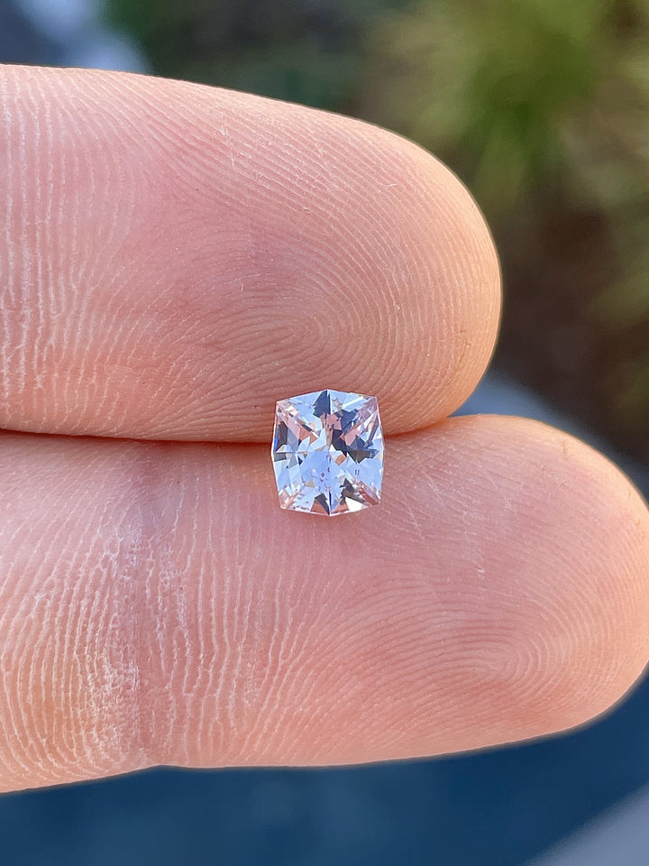 Close-up of a pink peach sapphire weighing 1.04 carats, showcasing its fancy mixed cushion cut with excellent clarity and sparkle, sourced from Sri Lanka.