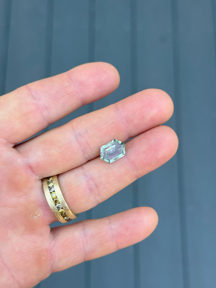 3.80 carat teal green Montana sapphire in step cut hexagon shape displayed on hand, ethically sourced and untreated