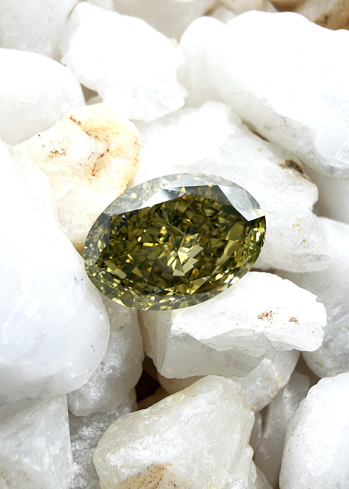 Oval cut Fancy Brownish Greenish Yellow diamond with a predominantly yellow color modified by greenish and brownish tones.