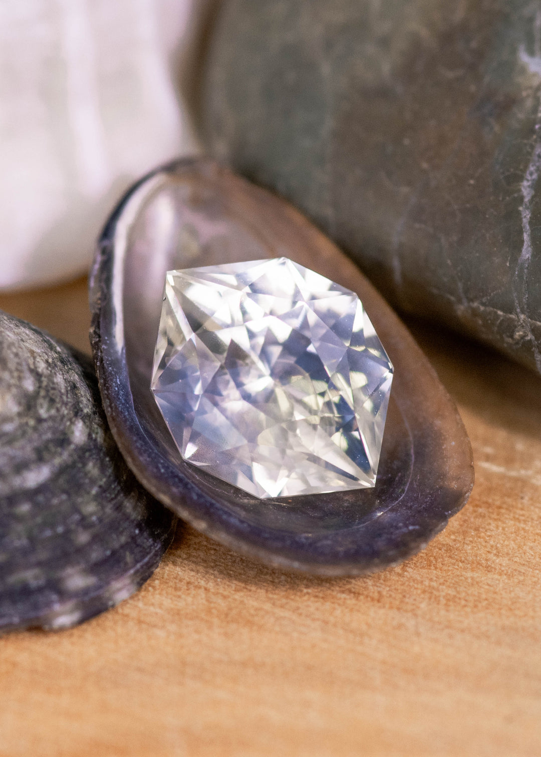 Loose pastel green and yellow sapphire from Sri Lanka displayed on natural stones highlighting the custom geometric marquise cut and soft pastel color.