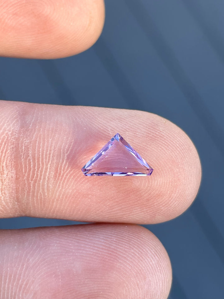 Close-up of a pink lavender Spinel gemstone weighing 1.02 carats, cut in a modified trillion portrait style.