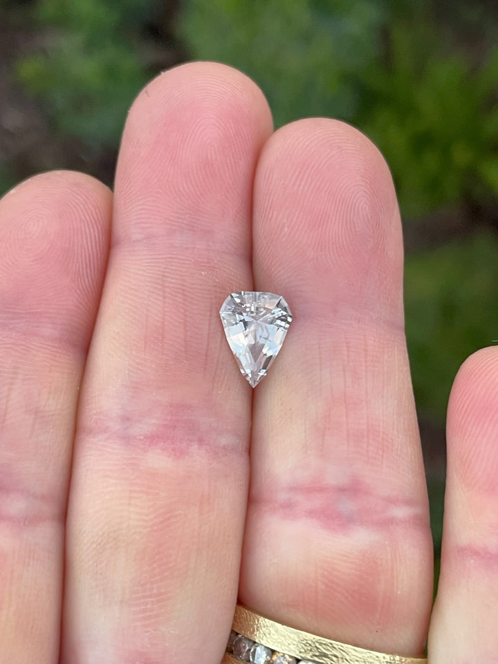 Close-up of a pink to peach color-changing sapphire with a modified geometric shield step cut. A fine 2.09-carat gemstone, ethically sourced from Sri Lanka and presented with no treatment.