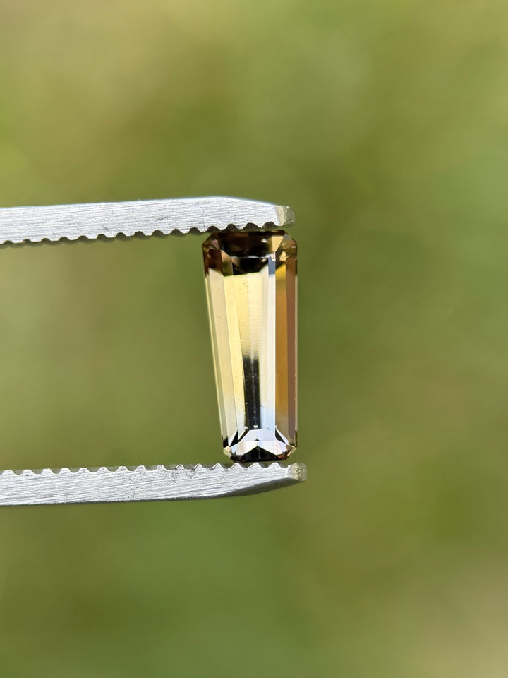 Close-up of 1.26CT multi-color Tanzanite in custom elongated tapered emerald cut.