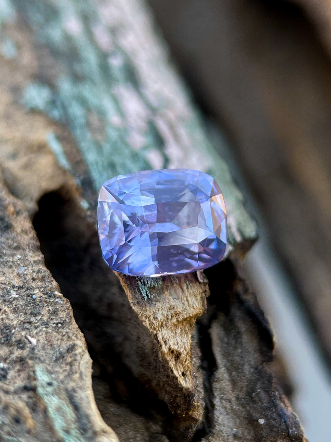 Detailed view of a 1.05 carat opalescent sapphire in a radiant cut, showcasing purple to pink tones, untreated and sourced from Sri Lanka.