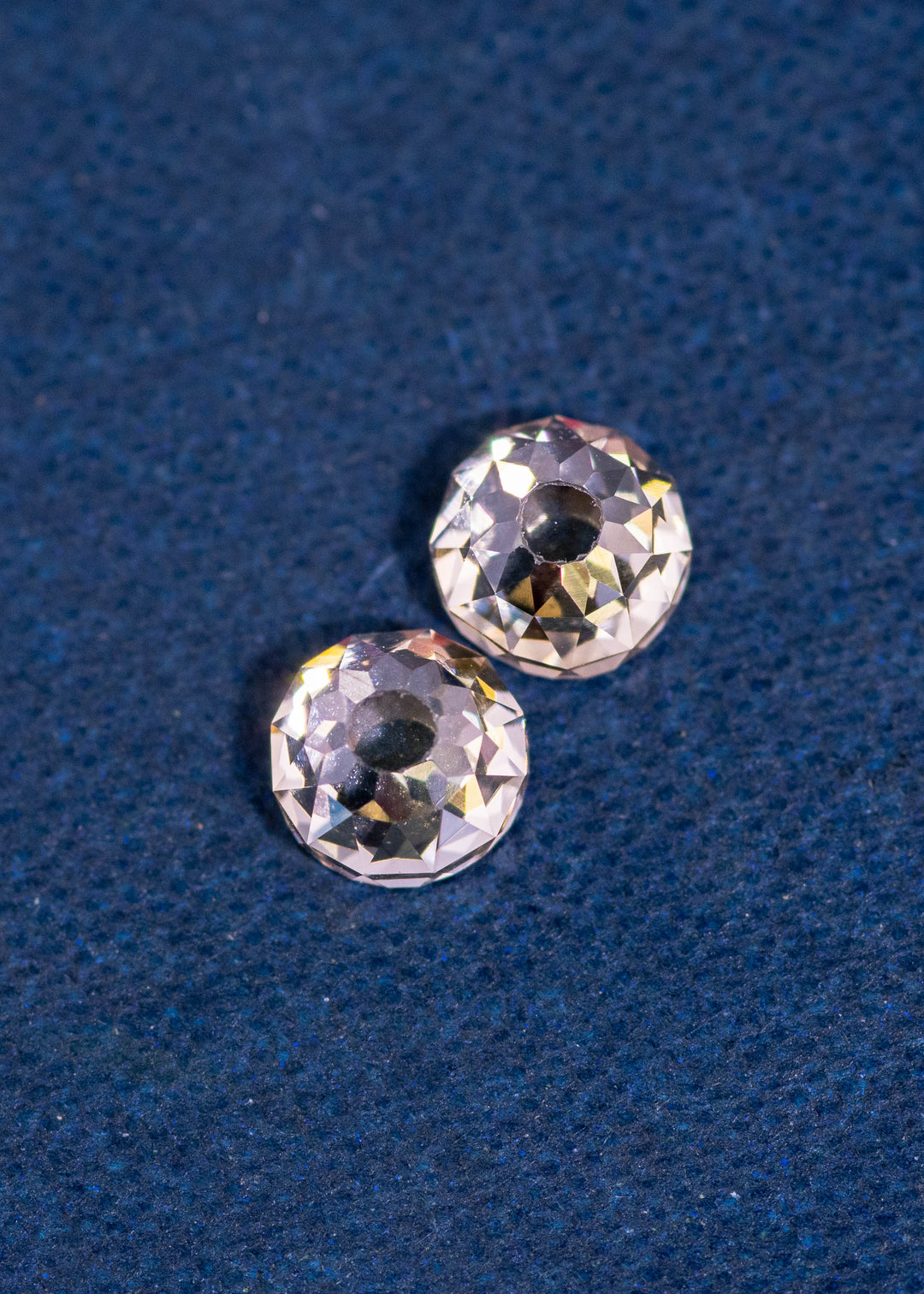 Pair of fancy brown Mughal cut diamonds totaling 1.45 carats photographed on a deep blue background, showcasing antique hand-cut faceting, natural color, and untreated South African origin.