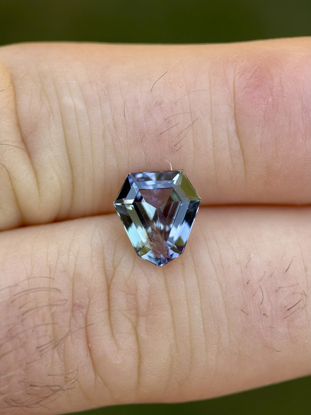 Close-up of untreated Tanzanite from Merelani Hills in a custom shield step cut, highlighting the vivid teal-green-purple tri-coloration