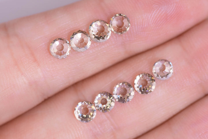 Nine Mughal cut fancy light brown VVS diamonds displayed on fingertips for scale, showing antique round faceting, open culets, and uniform sizing from South Africa