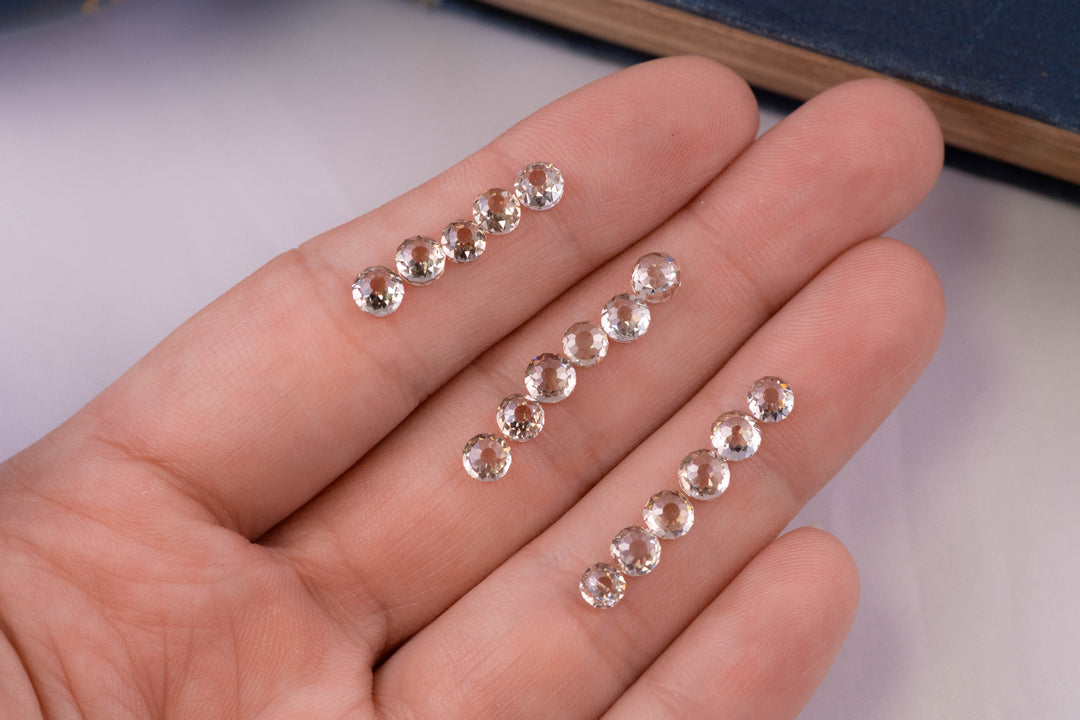 Handheld view of multiple Mughal cut diamonds displayed across fingertips, highlighting scale, fancy light brown color, VVS clarity, and historic antique cut geometry