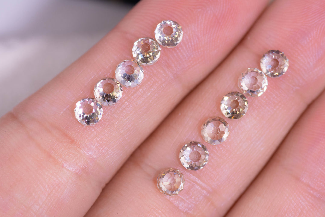Antique Mughal cut diamonds displayed on fingertips for scale, featuring 11 fancy light brown VVS clarity diamonds totaling 5.20 carats, highlighting hand-cut symmetry and historic diamond craftsmanship