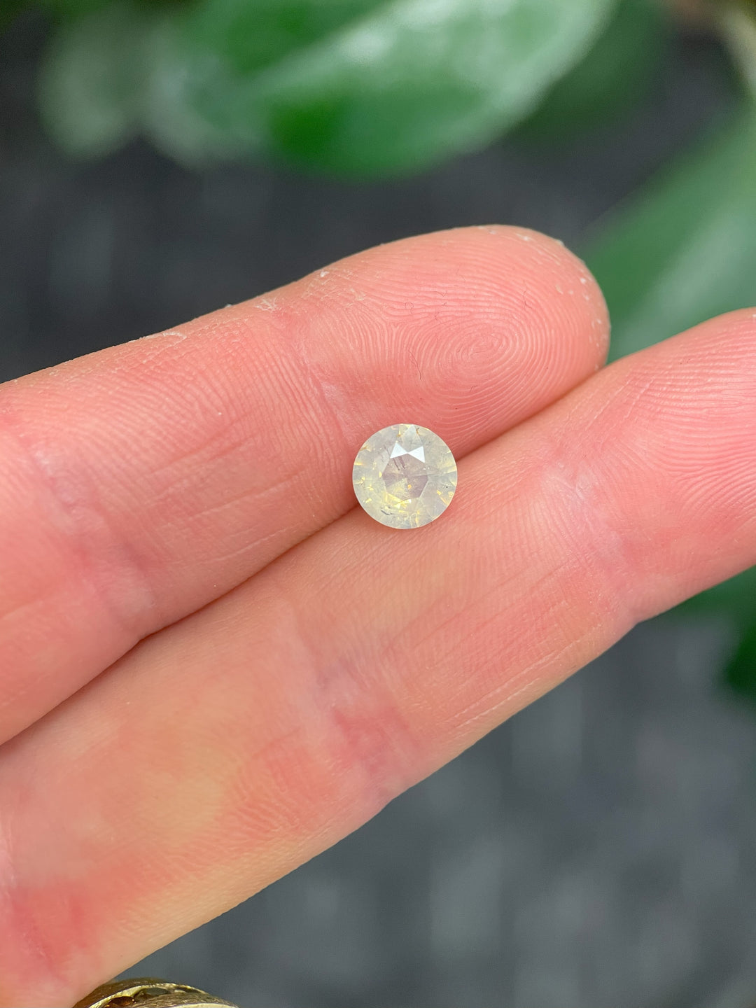2.08 carat round brilliant cut sapphire with white to yellow opalescence, sourced from Sri Lanka and untreated for natural clarity.