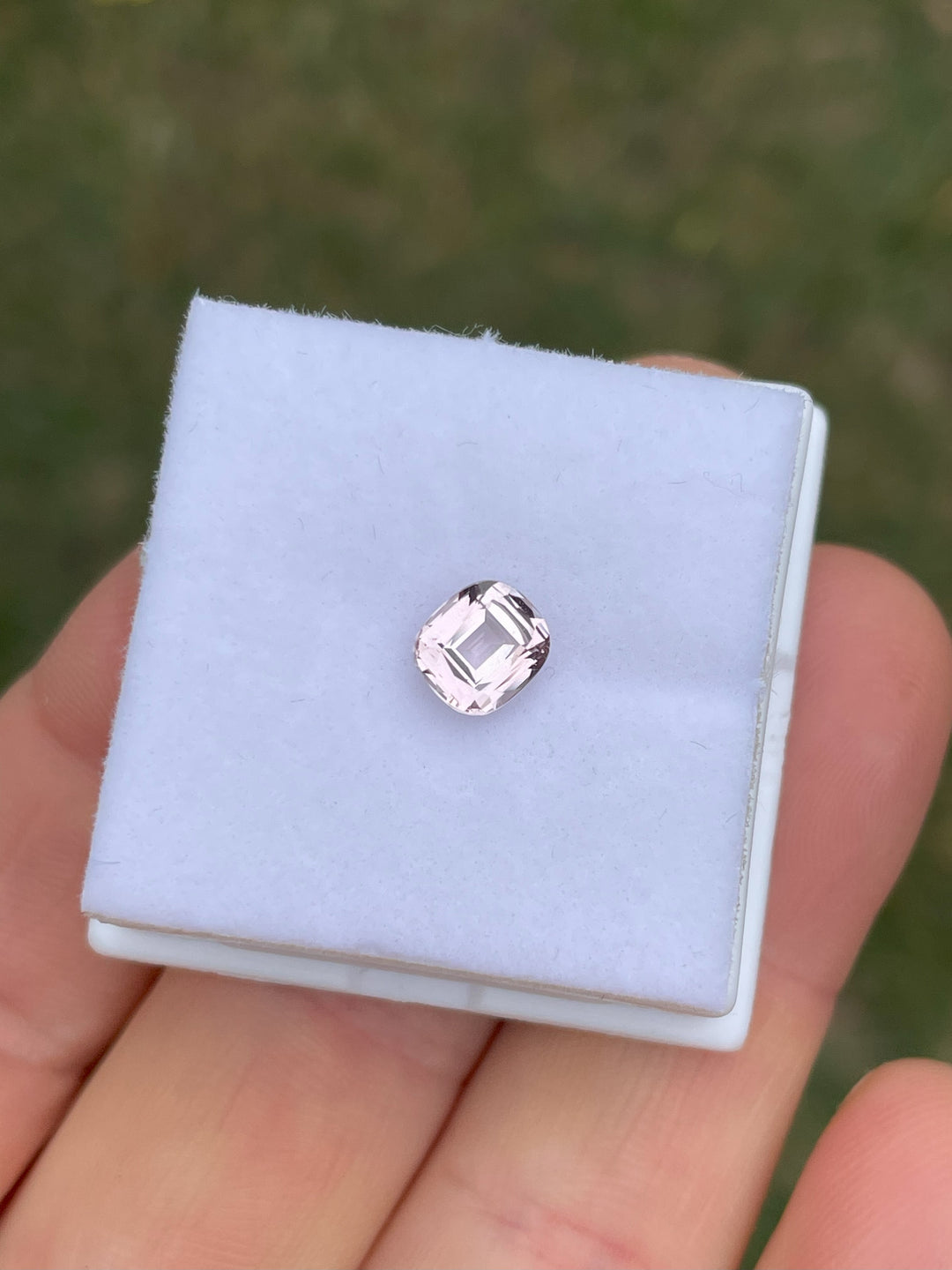 Pastel yellow and peach-colored sapphire, 1.19 carats, displayed in a small box with a modified cushion cut. Originating from Sri Lanka, this sapphire is untreated and has dimensions of 6.57mm x 5.79mm x 3.47mm.