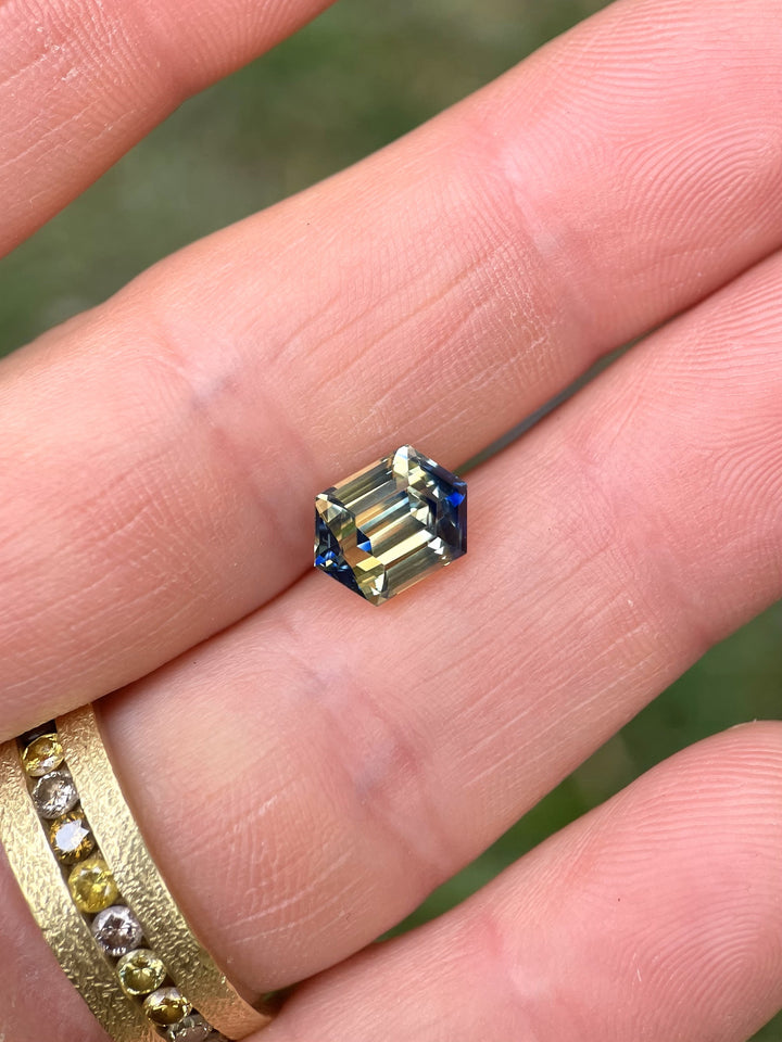 Macro view of a 4.13ct untreated sapphire with striking yellow and blue hues, precision-cut into a hexagonal step shape.