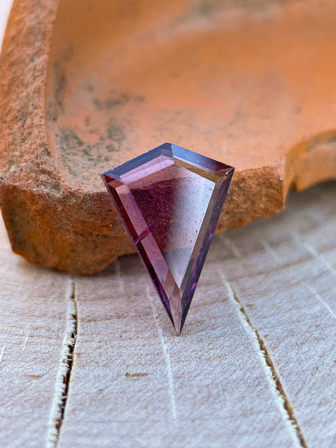 Detailed view of a 1.44 carat spinel gemstone in a custom kite portrait cut, with purple-pink hues and untreated clarity, sourced from Sri Lanka.