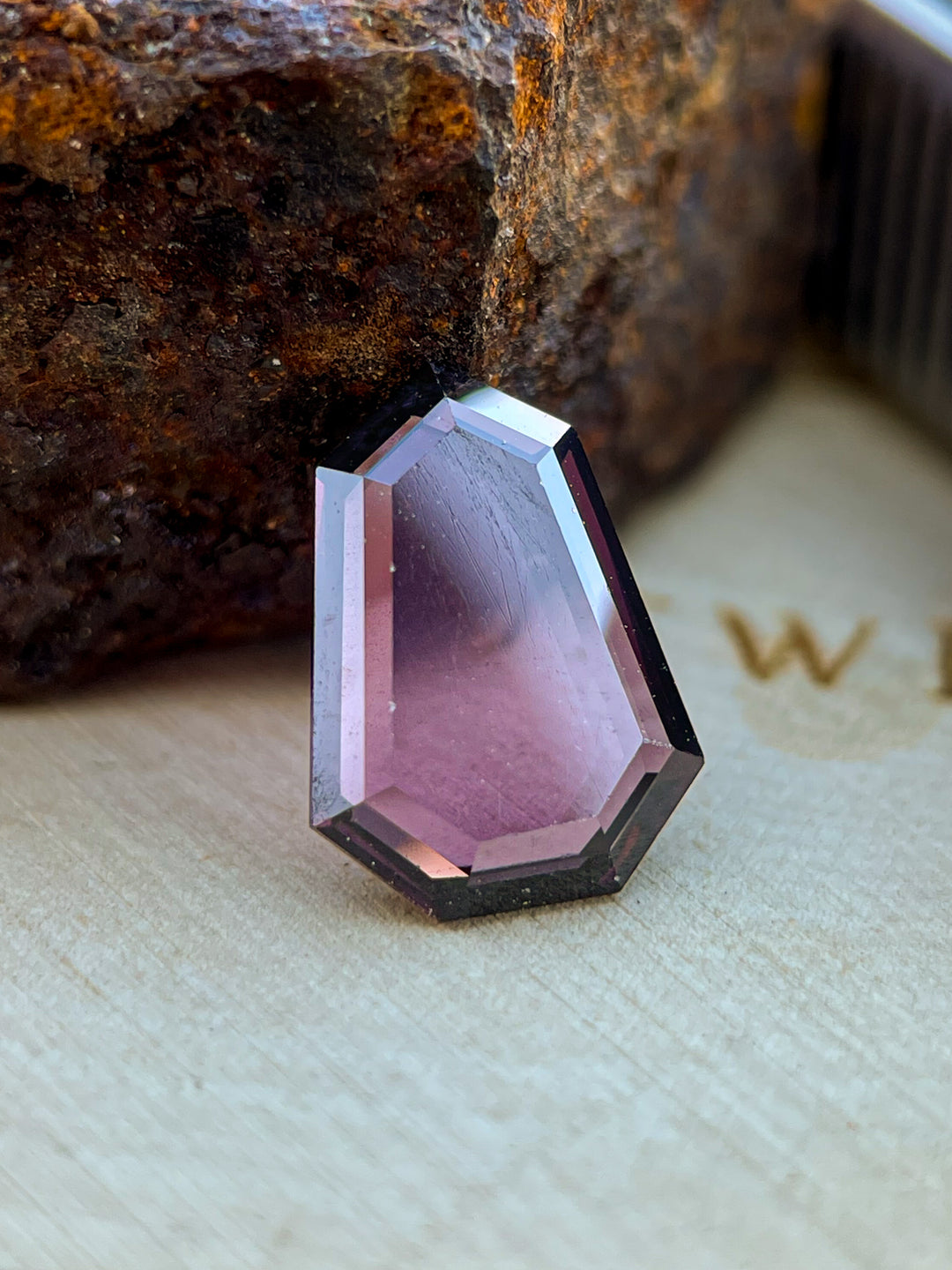 2.05 carat Sri Lankan spinel gemstone with a shield step cut, showing red-purple tones and untreated clarity, ideal for custom jewelry.