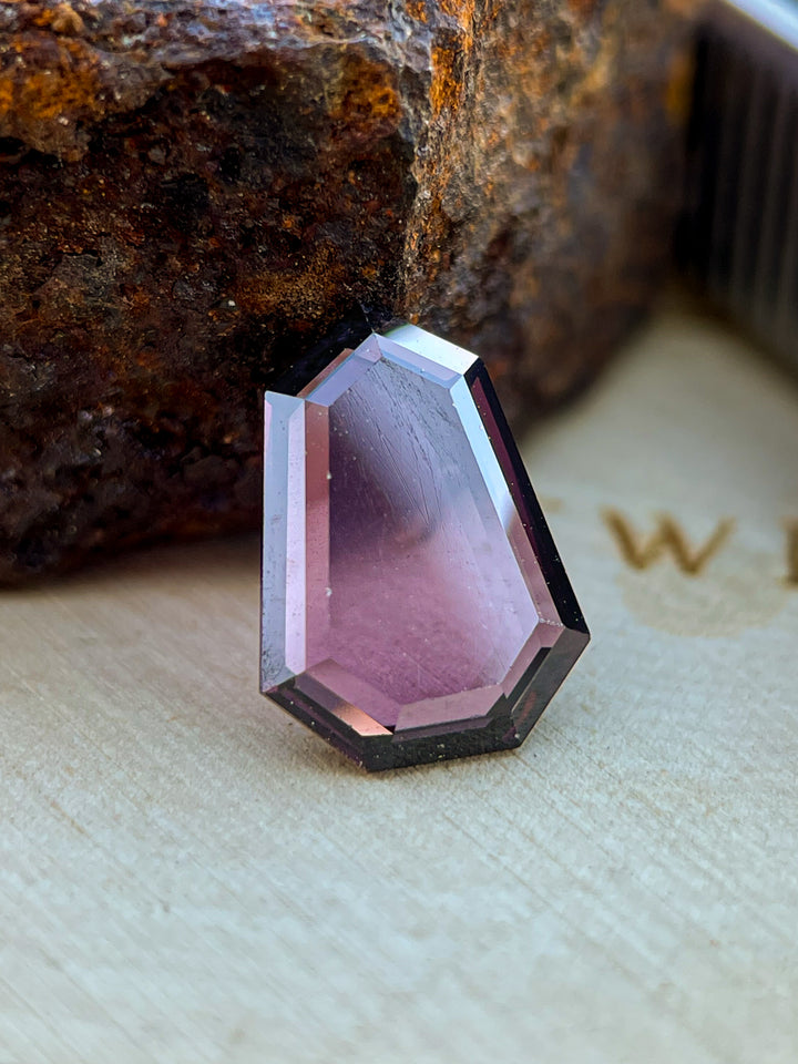 2.05 carat Sri Lankan spinel gemstone with a shield step cut, showing red-purple tones and untreated clarity, ideal for custom jewelry.