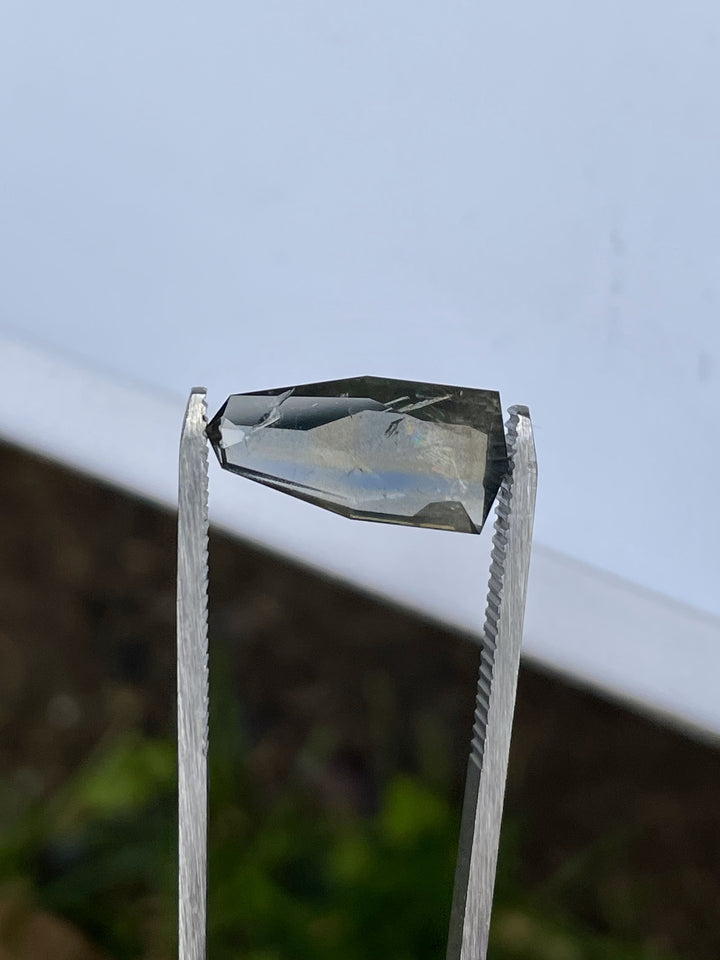 Close-up of elongated shield cut sapphire with rainbow iridescence and natural sheen, 6.74 carats