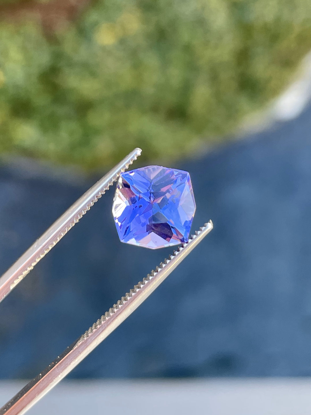 Close-up view of a 3.27-carat Tanzanite gem in ultra violet and purple tones, expertly cut into a geometric cushion shape. Originating from Merelani Hills, Tanzania, this gemstone is untreated and perfect for fine jewelry.