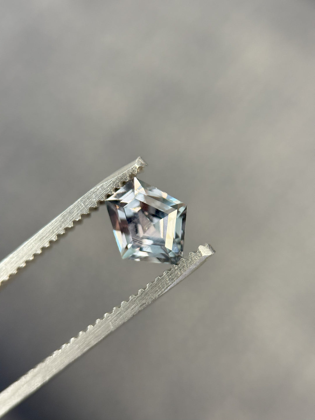 Dual lighting photo of color-change sapphire from Montana, shifting from teal blue to grey purple