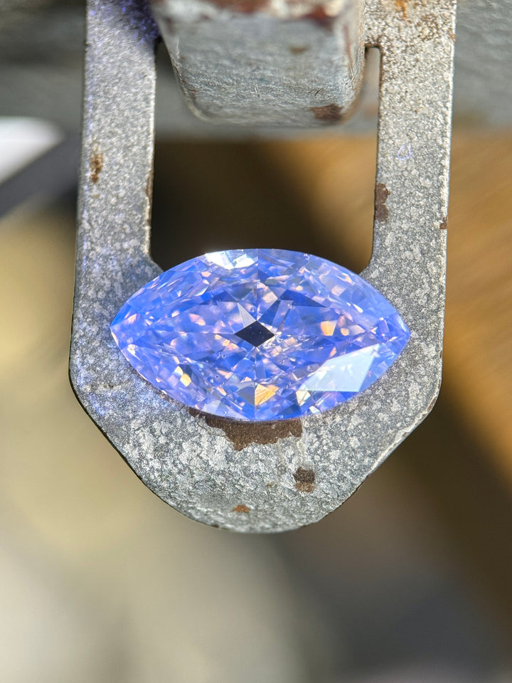 UV fluorescence view of a 4.01 carat rosy champagne fancy yellow brown diamond glowing vivid blue under ultraviolet light. The antique-style moval modified brilliant cut reveals strong blue fluorescence and intricate faceting.