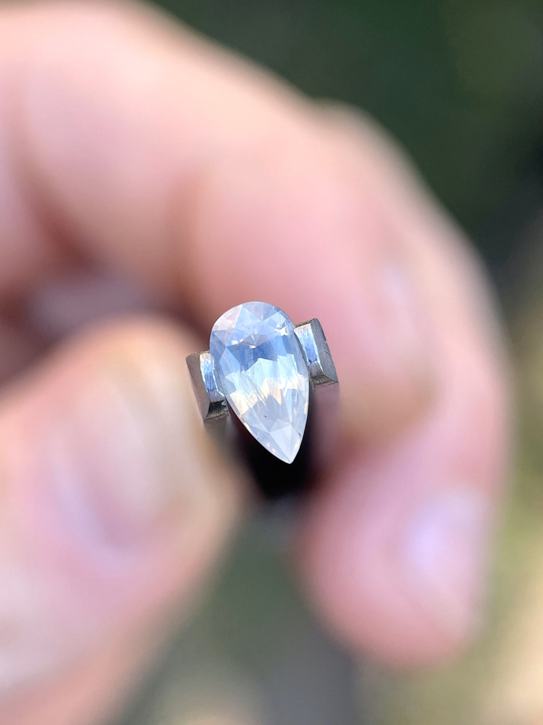 Natural pear brilliant cut sapphire glowing with peach luster.