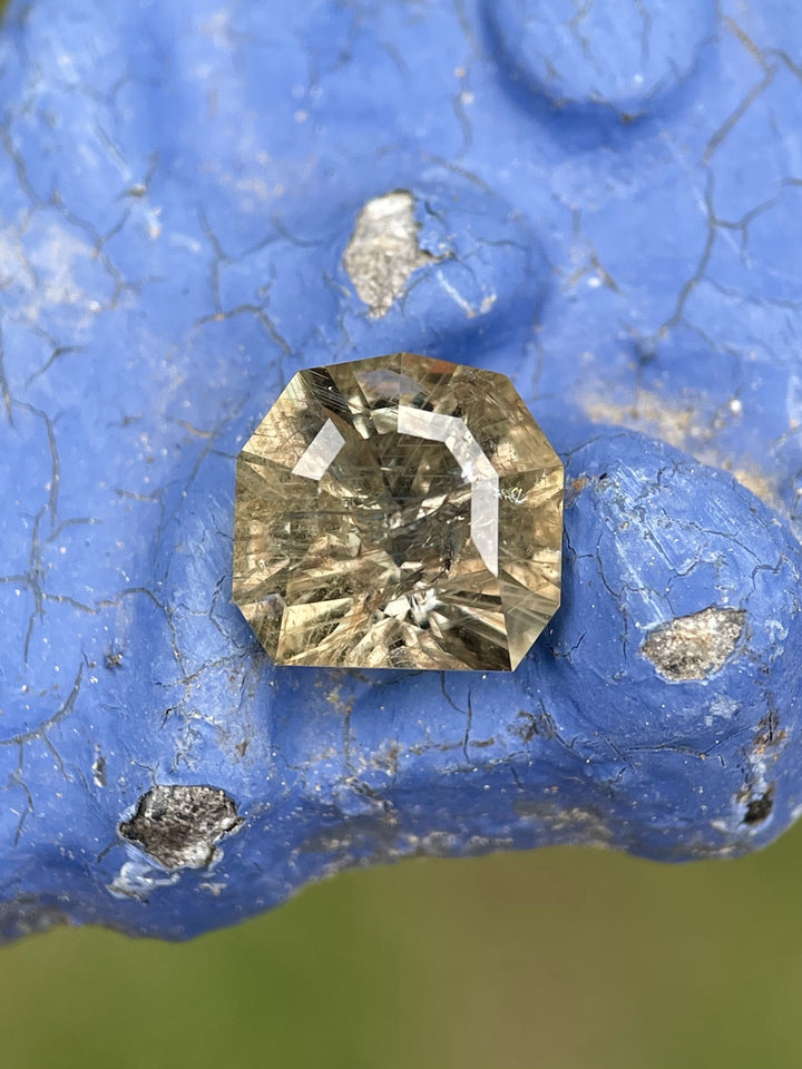 3.82ct natural Umba River sapphire resting on blue background, exhibiting color shift properties.