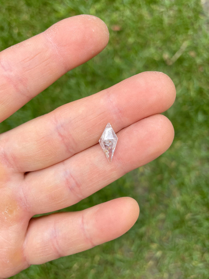 Detailed image of a silvery gray rhombohedral sapphire showing natural inclusions and clarity, weighing 2.85 carats.
