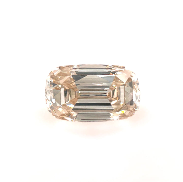A close-up of a 1.02-carat SI1 clarity champagne diamond with an elongated cushion cut, set against a white background to highlight its brilliance and vintage charm.