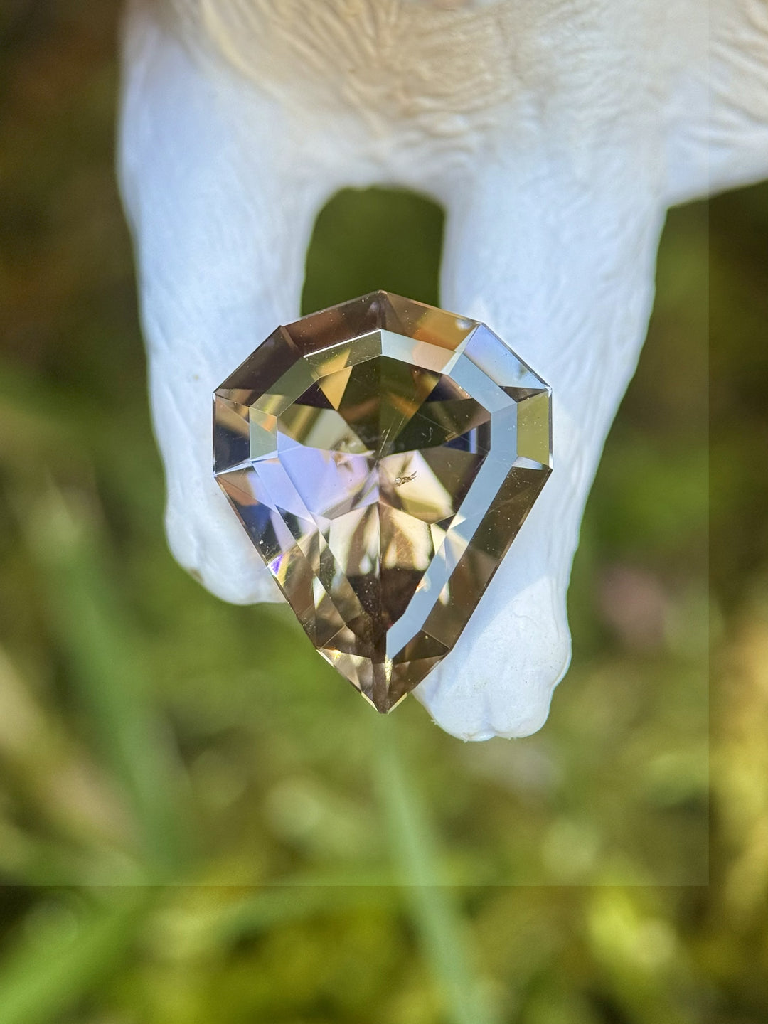 Unique 3.74ct Tanzanite displayed outdoors in natural light with strong purple and peach hues in shield cut