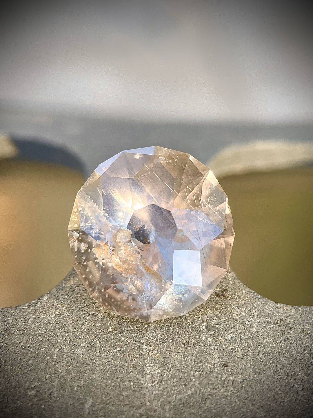 A stunning 6.38-carat sapphire with green, gray, and yellow hues, featuring a modified round Portuguese-style cut. Ethically sourced from the Umba River, Tanzania, and untreated, this gemstone offers a beautiful, natural aesthetic.