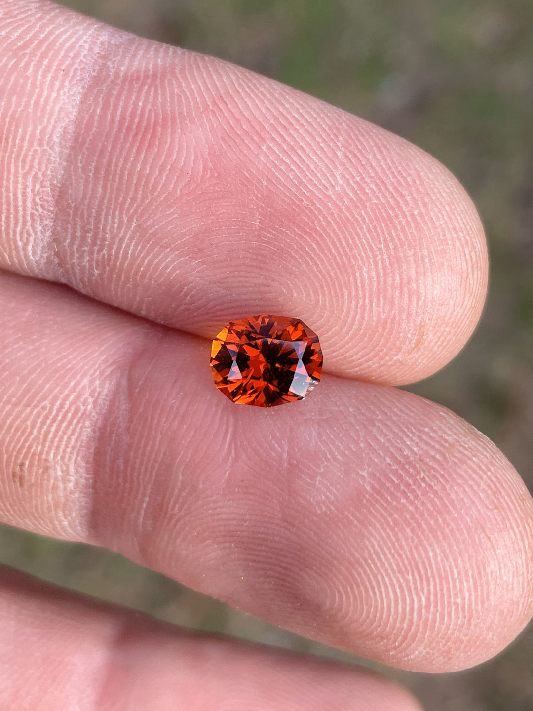 Close-up of a 1.68-carat Hessonite Garnet from Kenya, oval-cut with vivid red and orange color.