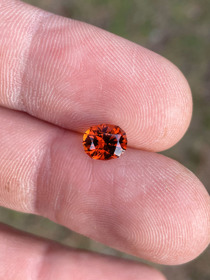 Close-up of a 1.68-carat Hessonite Garnet from Kenya, oval-cut with vivid red and orange color.