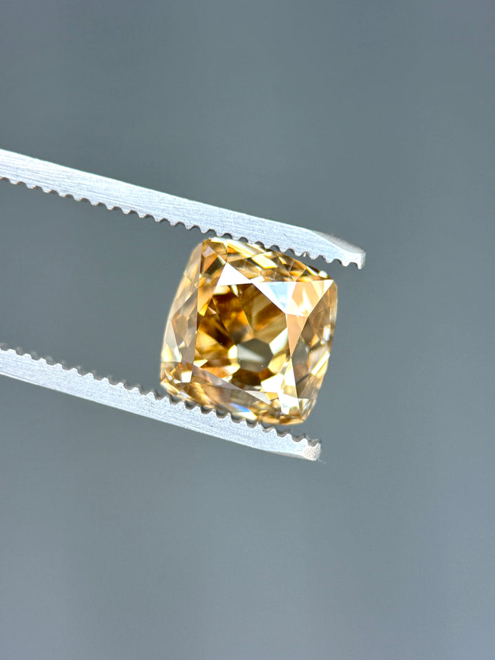 Natural Canadian champagne diamond displaying broad antique cushion facets with warm bronze and deep champagne reflections across the crown.
